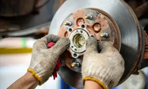 Mechanik sprawdza piastę koła, która może być przyczyną objawów zużytego łożyska koła: huczenie w zakrętach.