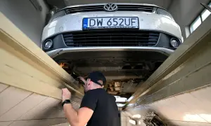 Mechanik sprawdza podwozie Volkswagena. Długie terminy oczekiwania na blacharza w marcu 2026 r. to nawet 3 miesiące.