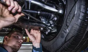Mechanik pracuje pod samochodem. Prawdziwa historia klienta, który stracił gwarancję przez wymianę klocków poza ASO.