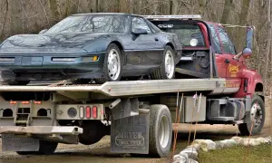 Zielony Chevrolet Corvette na czerwonym samochodzie holowniczym.