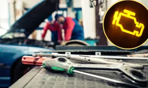Prawda o rzekomym zakazie naprawiania aut starszych niż 20 lat w autoryzowanych serwisach. Kontrolka silnika świeci się, a mechanicy pracują nad autem.