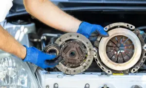 Mechanik pokazuje zużyte części: sprzęgło i dwumasę. Dowiedz się, ile kosztuje wymiana sprzęgła i dwumasy.