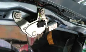 Mechanizm wycieraczki tylnej szyby, gotowy do wymiany. Widać silniczek, złącze elektryczne i mocowania.