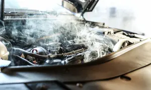 Dymiący silnik samochodowy, ilustrujący skutki przegrzania silnika aluminiowego a żeliwnego.