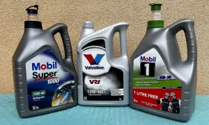 Trzy butelki oleju silnikowego: Mobil Super 1000, Valvoline VR1 i Mobil 1.