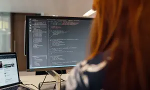 Programista pracuje nad kodem, który może być kluczowy dla ustalenia, kto kontroluje legalność oprogramowania diagnostycznego w małych warsztatach.