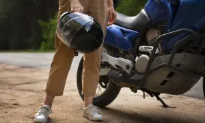 Osoba trzyma kask obok niebieskiego motocykla. Zastanawiasz się, czy można holować motocykl?
