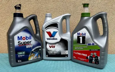 Trzy butelki oleju silnikowego: Mobil Super 1000, Valvoline VR1 i Mobil 1.