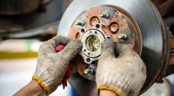 Mechanik sprawdza piastę koła, która może być przyczyną objawów zużytego łożyska koła: huczenie w zakrętach.