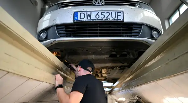 Mechanik sprawdza podwozie Volkswagena. Długie terminy oczekiwania na blacharza w marcu 2026 r. to nawet 3 miesiące.