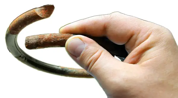 Zardzewiały, pęknięty element zawieszenia, ilustrujący przyczyny pękania sprężyn zawieszenia w autach miejskich.