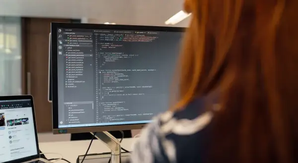 Programista pracuje nad kodem, który może być kluczowy dla ustalenia, kto kontroluje legalność oprogramowania diagnostycznego w małych warsztatach.