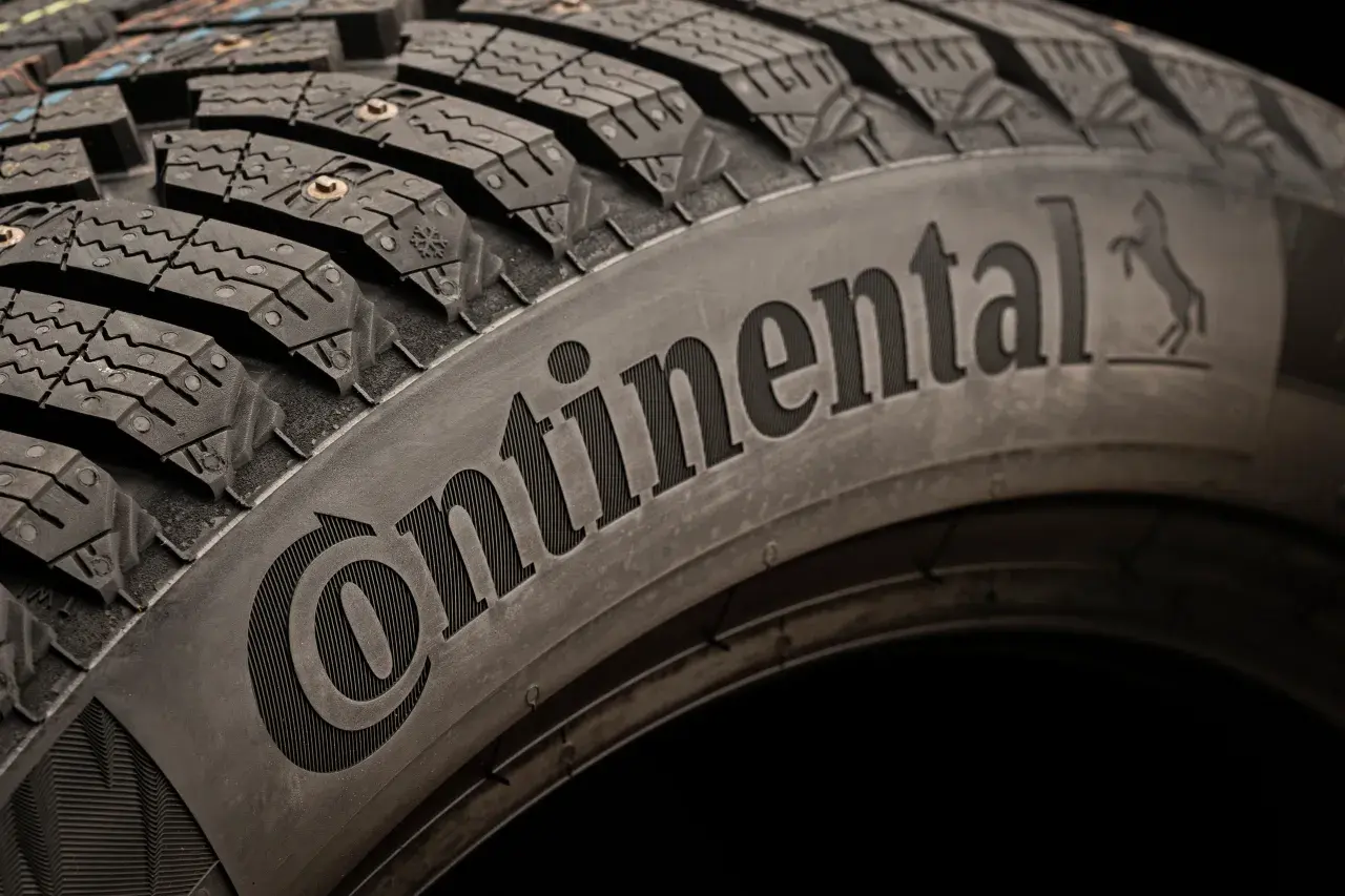 Opona zimowa z kolcami, z napisem Continental. To właśnie ta firma produkuje opony Continental, zapewniając przyczepność na lodzie.
