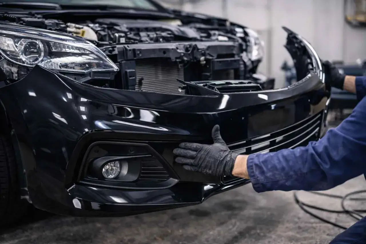 Rękawiczki mechanika pokazują różnicę między zderzakiem sportowym a seryjnym w montażu.