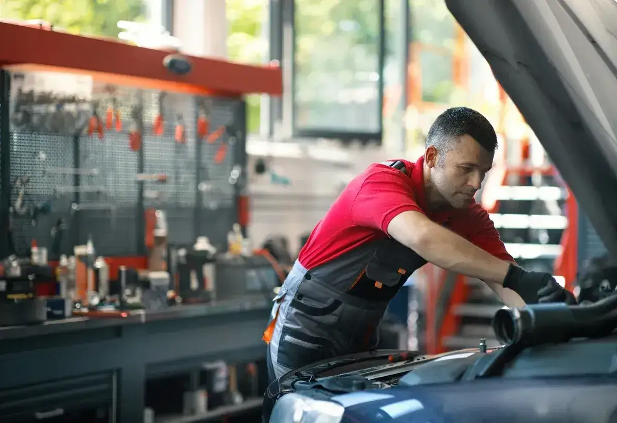 Mechanik pracuje przy silniku. Pamiętaj, że prawdziwa historia klienta który stracił gwarancję przez wymianę klocków poza ASO, może być przestrogą.