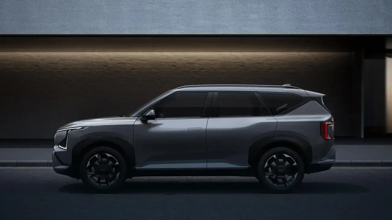 Nowoczesny, szary SUV Kia EV9 stoi na tle betonowej ściany. Od 2026 r. każdy serwis musi oferować zastępcze auto elektryczne, a ten model idealnie się do tego nadaje.