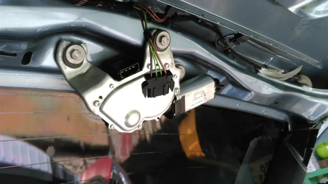 Mechanizm wycieraczki tylnej szyby, gotowy do wymiany. Widać silniczek, złącze elektryczne i mocowania.