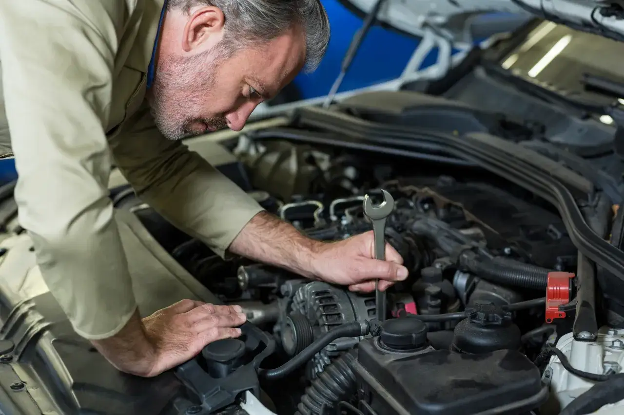 Mechanik sprawdza poziom płynu wspomagania kierownicy, który może być przyczyną objawów takich jak cięższe skręcanie.