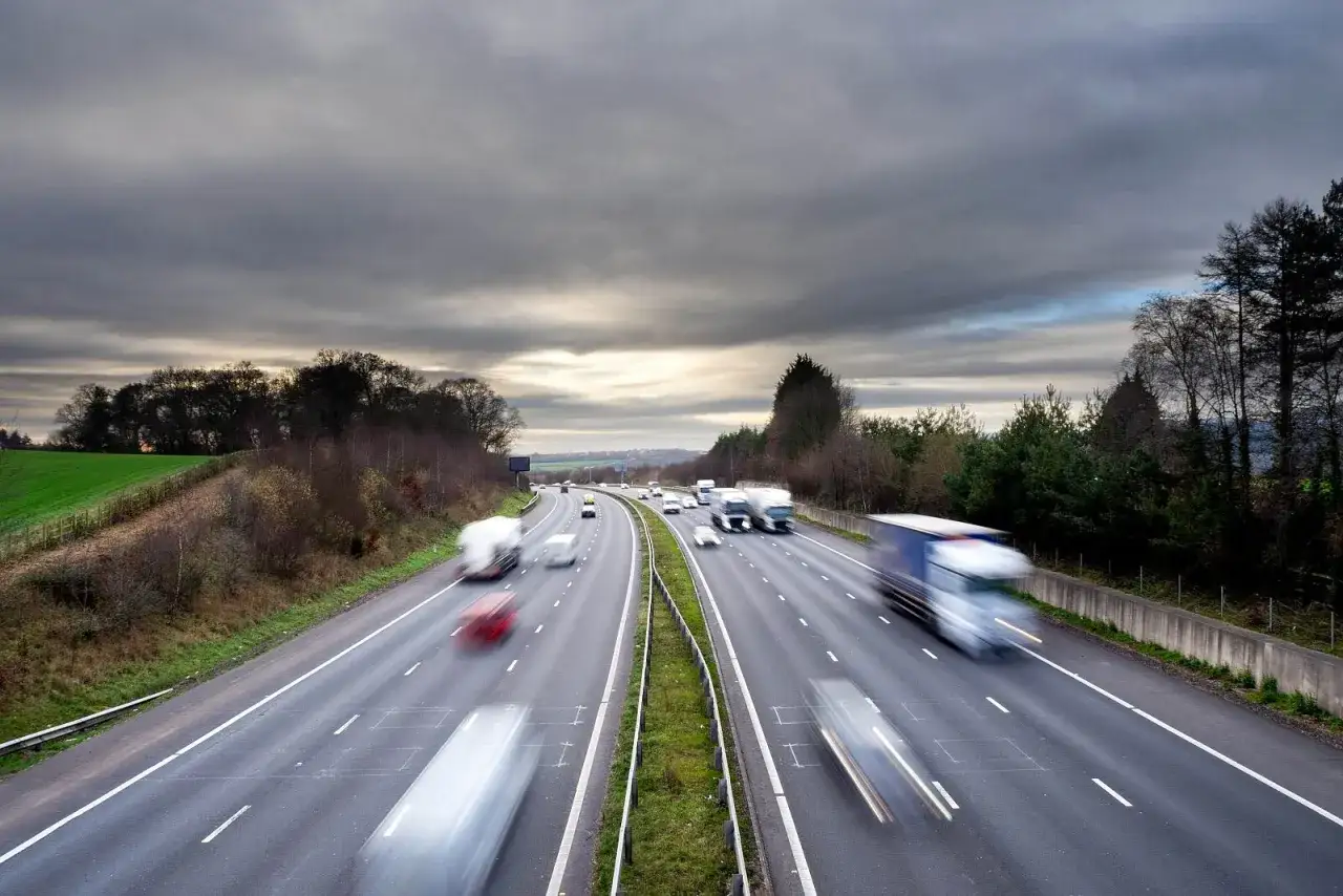 Autostrada z rozmytymi samochodami i ciężarówkami. Długie przejazdy autostradą to dobry sposób, jak wypalić dpf podczas jazdy.