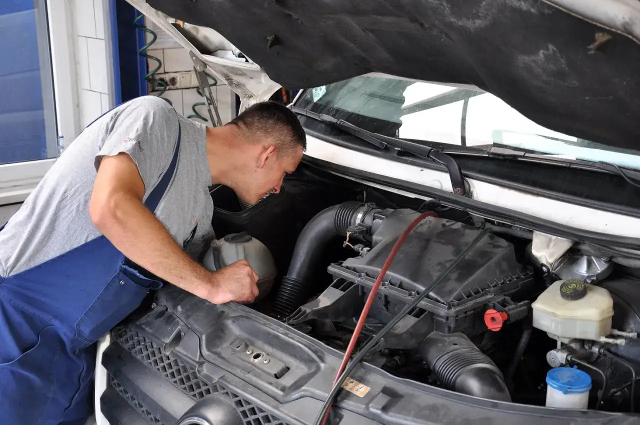 Mechanik bada silnik, szukając objawów spalania oleju przez uszczelniacze zaworowe a pierścienie.