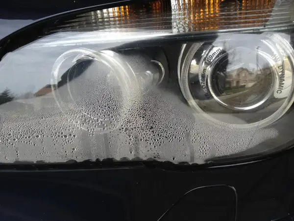Krople wody na kloszu reflektora BMW. Przyczyny parowania reflektorów po demontażu zderzaka mogą być związane z nieszczelnością.